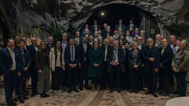Home Eine große Gruppe posiert in einer Felsenhöhle für ein gemeinsames Foto