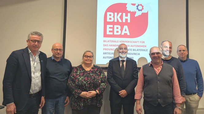 Home Sieben Personen posieren vor einer Leinwand mit BKH EBA Logo und Text