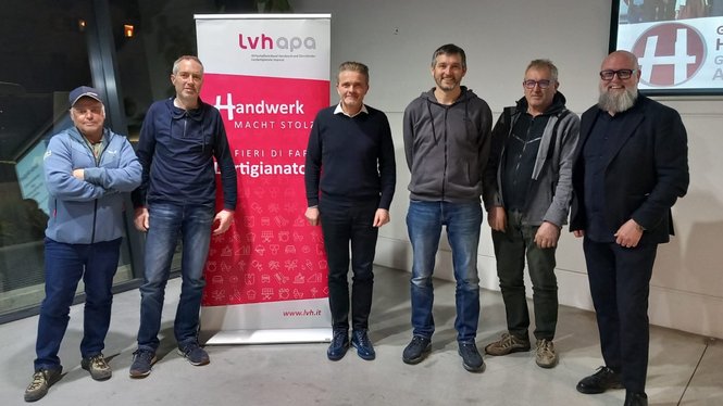 Home Sieben Männer stehen vor einem Banner des Handwerksverbands lvh appa
