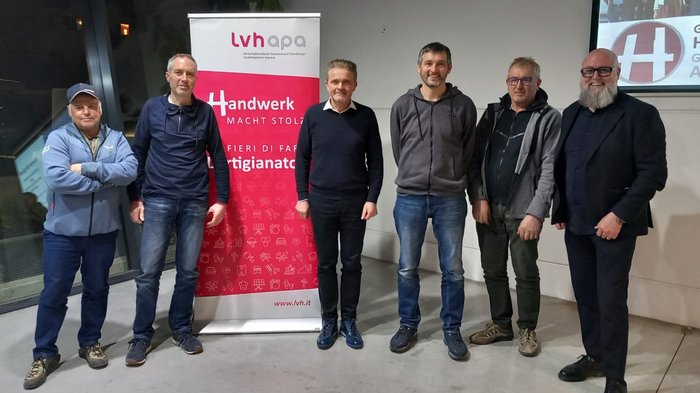 Mittelschule Lana: Berufe praxisnah erleben Sieben Männer stehen vor einem Banner des Handwerksverbands lvh appa