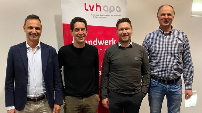 Home Vier Männer lächeln vor einem lvhapa-Banner