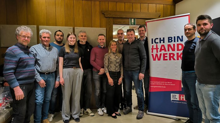 Mittelschule Dorf Tirol: Berufe praxisnah erleben Gruppe von Personen vor einem Banner mit Aufschrift Ich bin Handwerk