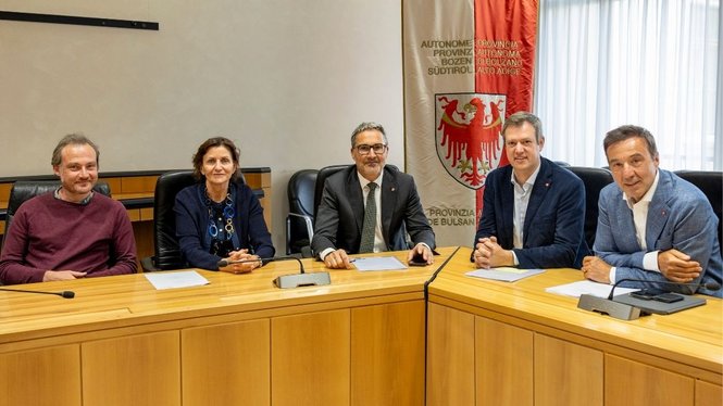 Home Fünf Personen sitzen bei einer Sitzung an einem Konferenztisch mit Südtiroler Wappen