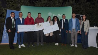 News Gruppenbild bei Preisverleihung mit großen Schecks und Raiffeisen Hintergrund