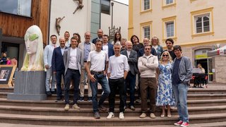 News Gruppo di persone posa sulle scale davanti a edifici durante mostra d'arte