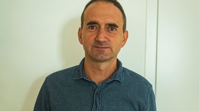 Home Mann mit kurzem Haar und blauem Hemd vor weißer Wand