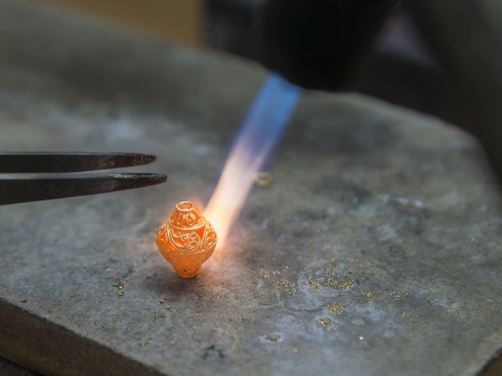 Percorso formativo Orafo modella un gioiello d'oro finemente lavorato con una fiamma