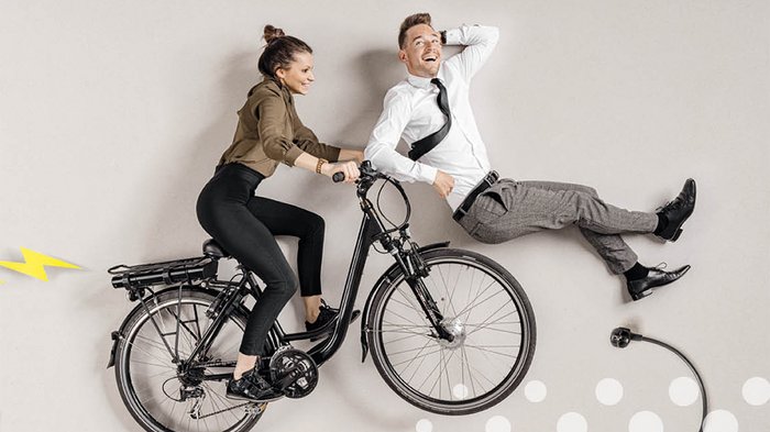 Mittelschule „Carl Wolf“: Einblicke in die Welt der Berufe im Handwerk und dem Gastgewerbe Frau fährt elektrisch unterstütztes Fahrrad mit lachendem Mann daneben