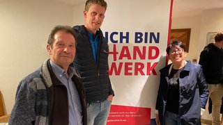 News Drei Personen stehen vor einem Banner mit dem Text Ich bin Handwerk