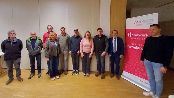 Home Eine Gruppe von neun Personen steht vor einer Wand und einem LVH-APA Banner