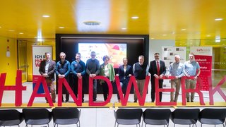 News Gruppenfoto von zehn Personen hinter roten Buchstaben, die #HANDWERK bilden