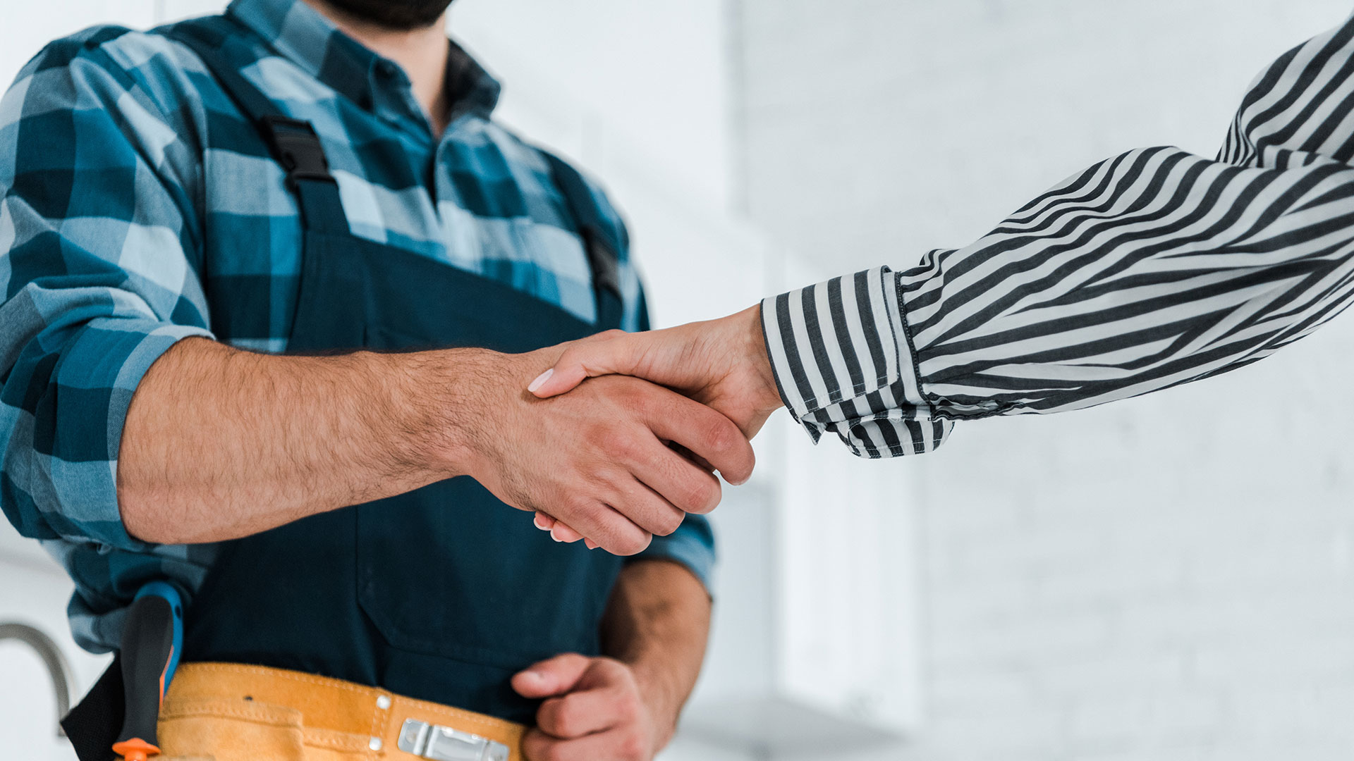 Home Handschlag zwischen Handwerker und Geschäftsperson mit eng anliegender Kleidung